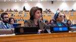  IOC Member, Laura Chinchilla, sitting at a desk and speaking into microphone
